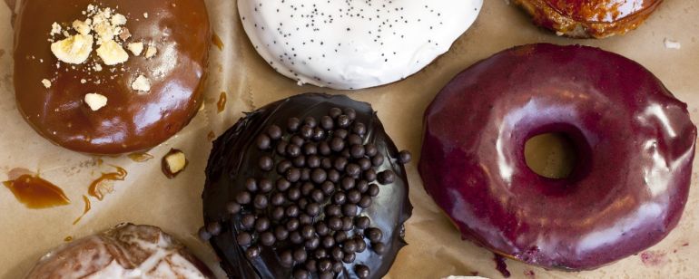seven gourmet donuts on parchment paper