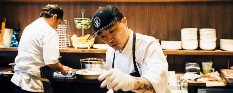 a cook prepares food in a pan