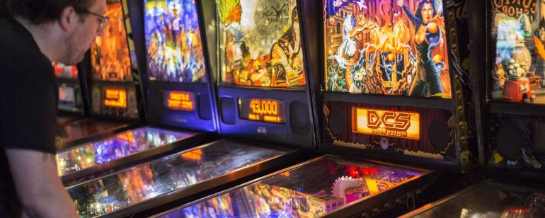 a man playing pinball