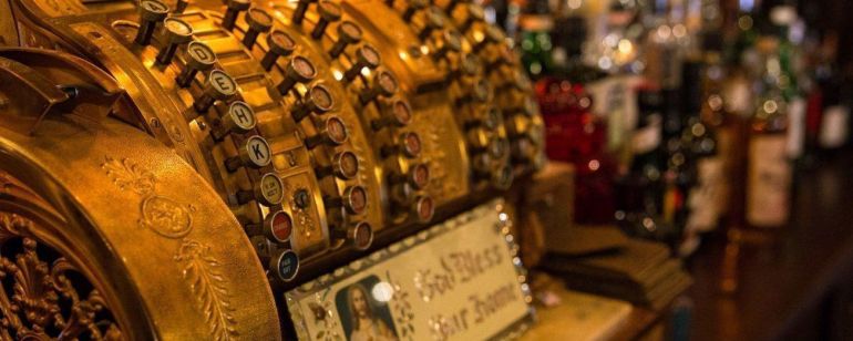an old-time cash register on a bar