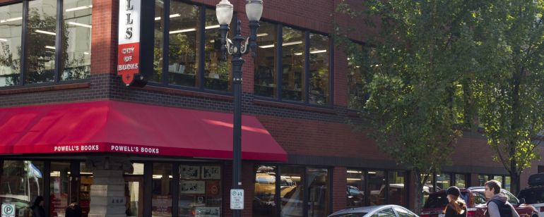 people crossing the street walking towards the exterior of Powell\'s Books