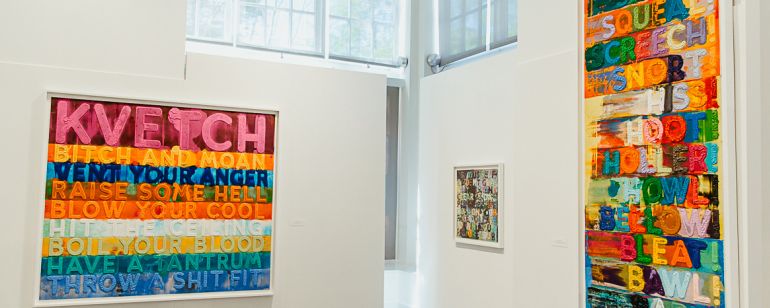 colorful paintings at the jewish museum. one says \"KVETCH\" in block letters.