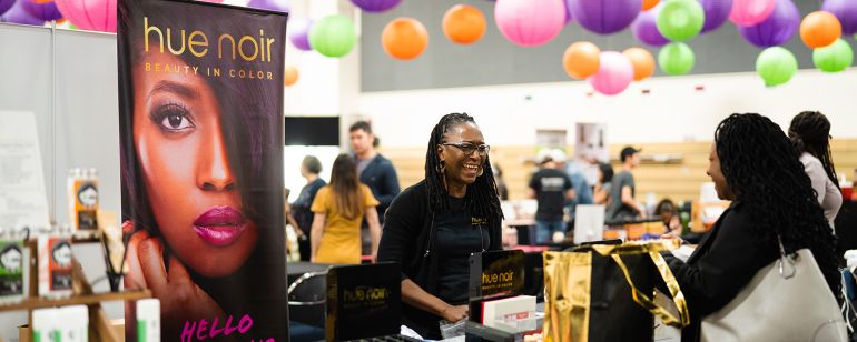 A vendor greets an attendee at My People\'s Market