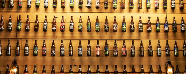 beer bottles displayed in lines against a wall