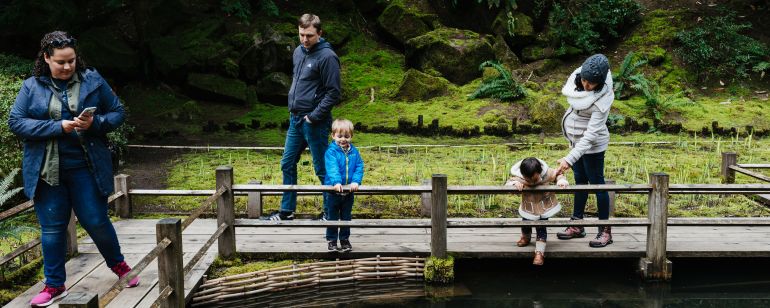 Family admires coi pond at Portland Japanese Garden