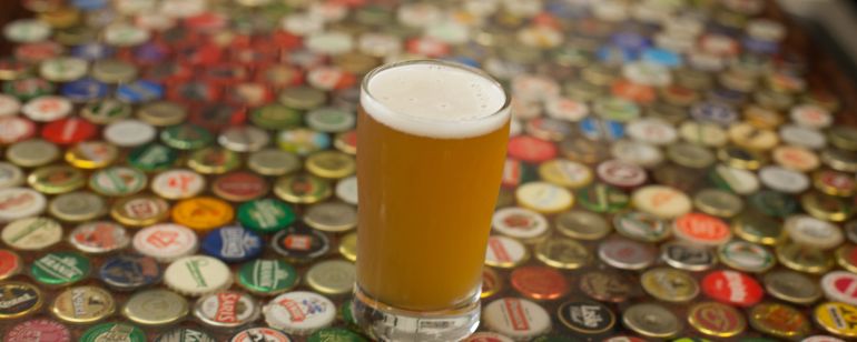 Pint of beer on bottlecap table
