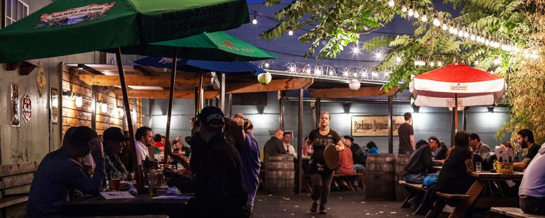 outdoor tables at a pub at night full of customers