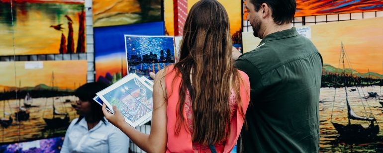 two people look at art on display