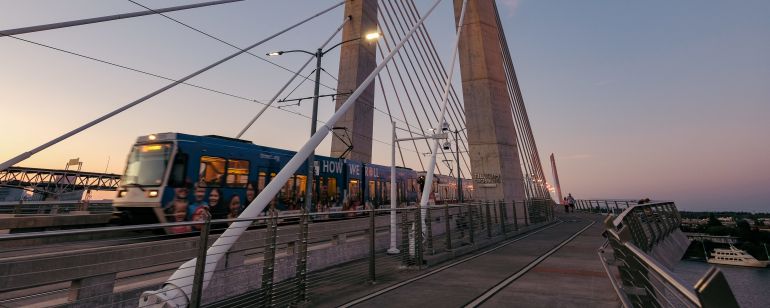 A light rail train crosses a bridge