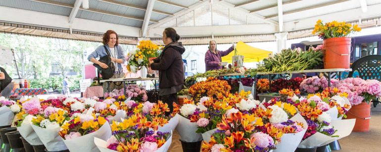 flower vendor selling a bouquet at a farmers market