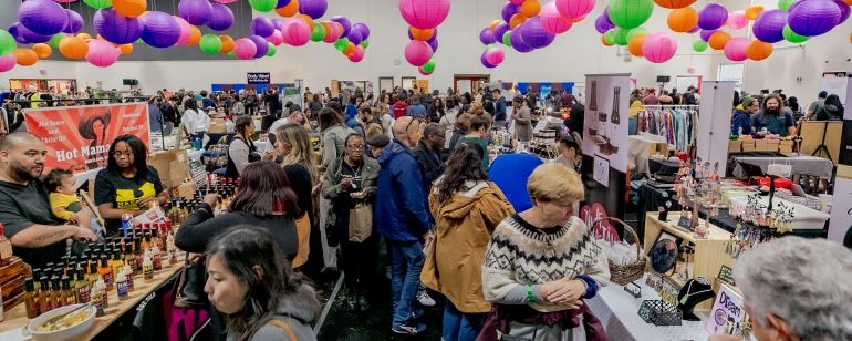 people shopping for arts and crafts in a bright space with colorful paper lights hanging from the ceiling