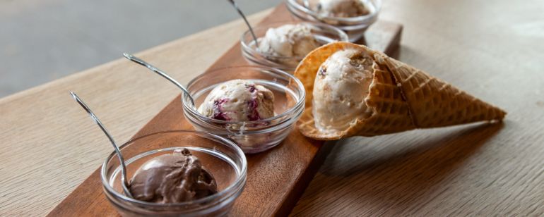 an ice cream sampler consisting of four small bowls and one sugar cone