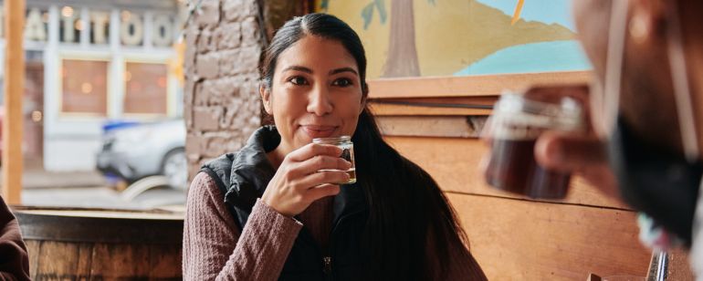 a woman enjoys a shared drink with friends