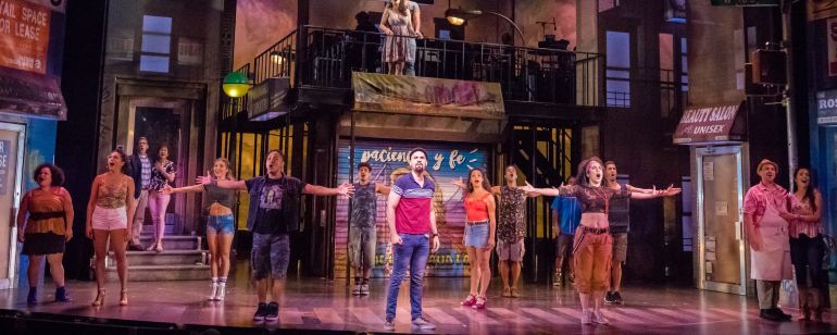 the cast of a musical theater show on stage singing during a performance