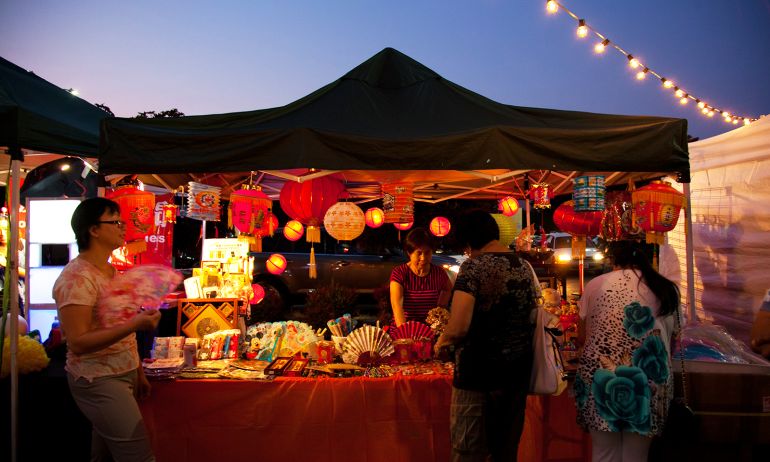 person selling products under a tent at an outdoor market