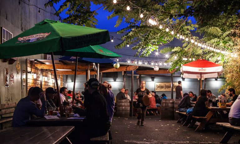 outdoor tables at a pub full of customers at night