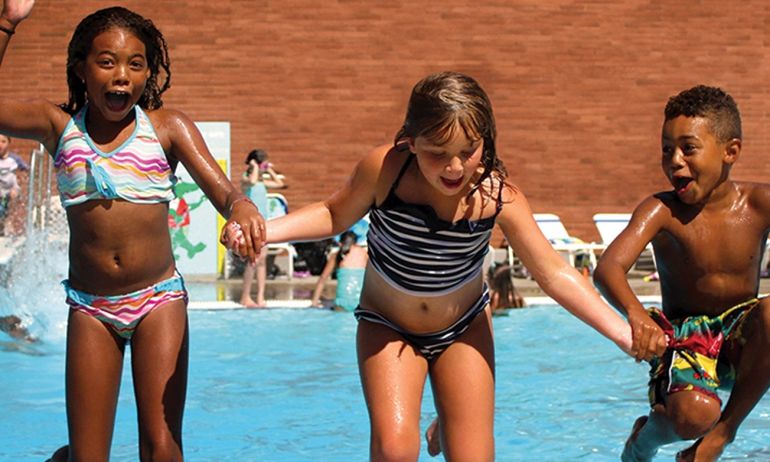 three children holding hands in a pool