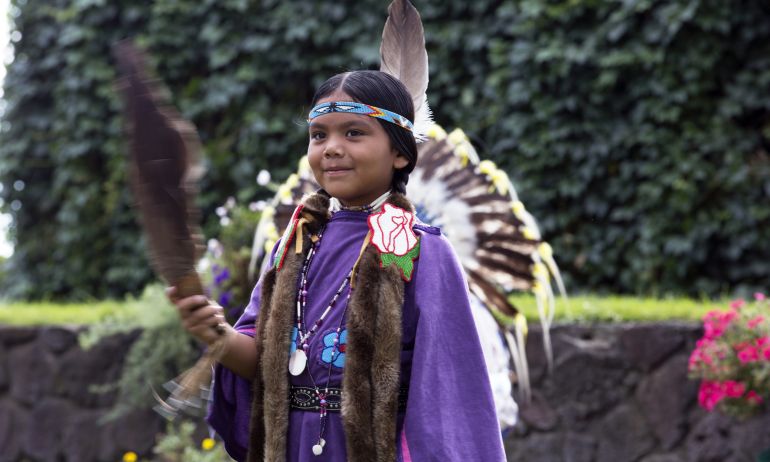 a girl dressed in Native American dance regalia