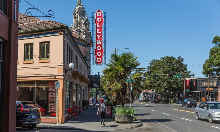 people walking on the sidewalk under a vintage Hollywood Theater sign