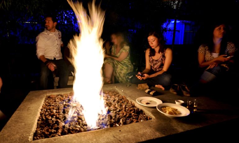 people sitting around a fire pit at night