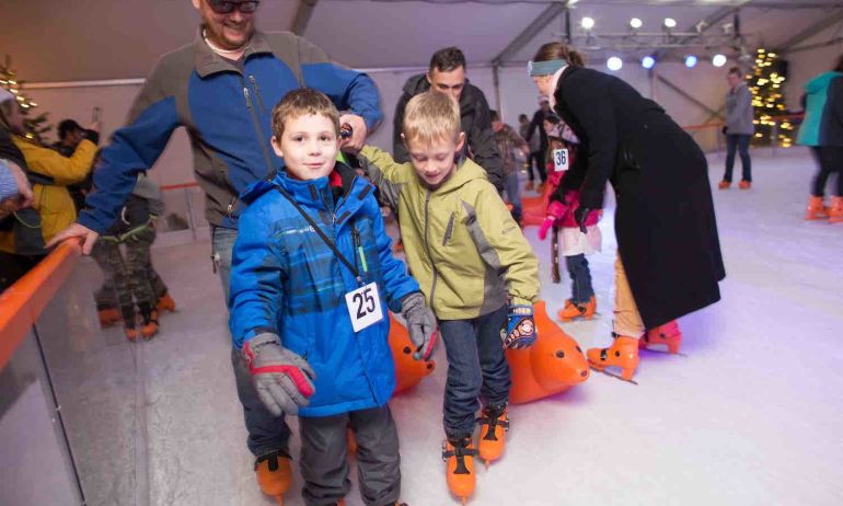 two children and a man on ice skates