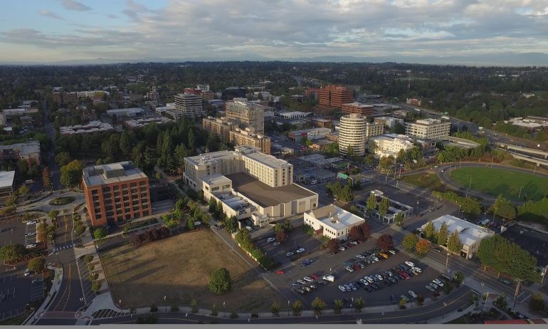 aerial view of a small downtown with about a dozen midrise buildings and a tree-filled park