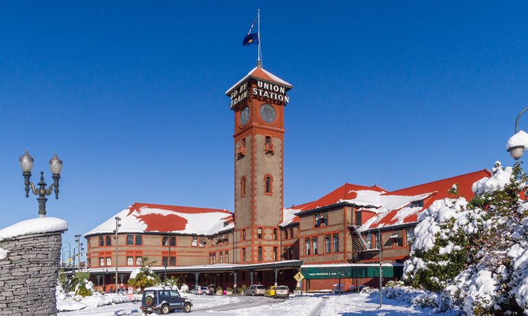 train station surrounded by snow-covered streets and shrubs