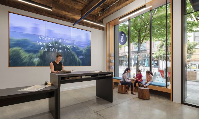 People sitting in the entryway at the Portland Visitor Center, reading brochures and socializing.