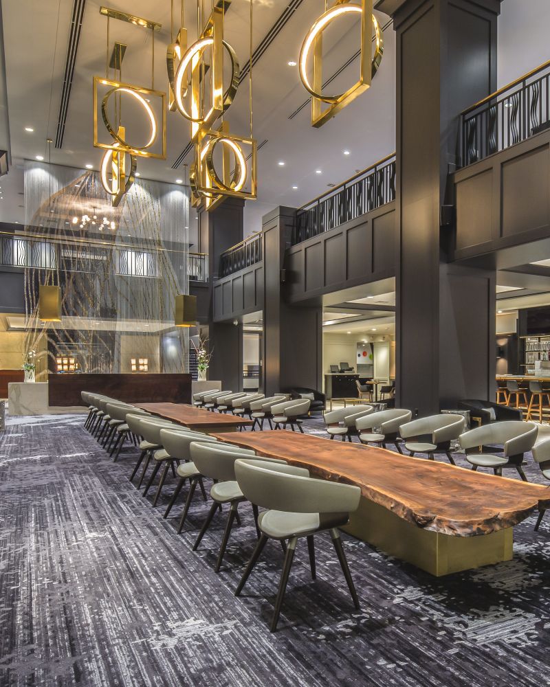 Long wooden tables set with chairs in the restaurant at the Hilton Downtown Portland