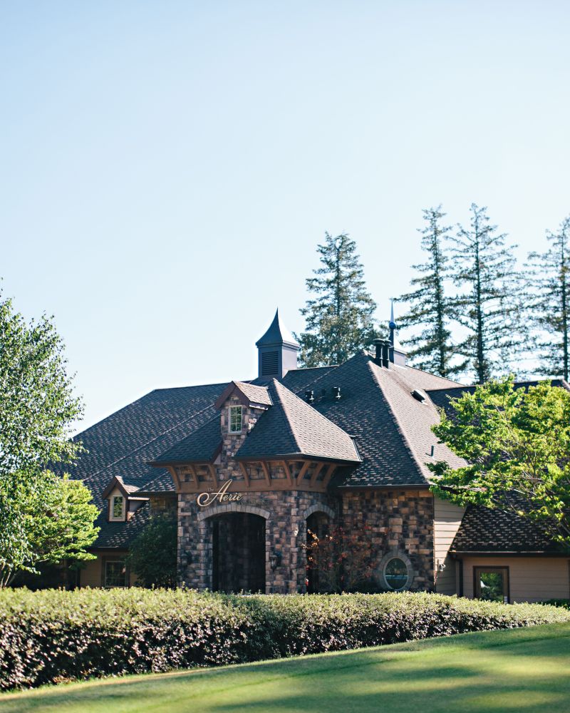 Exterior of a brick building with Aerie logo above the front door and sprawling gardens leading up to it