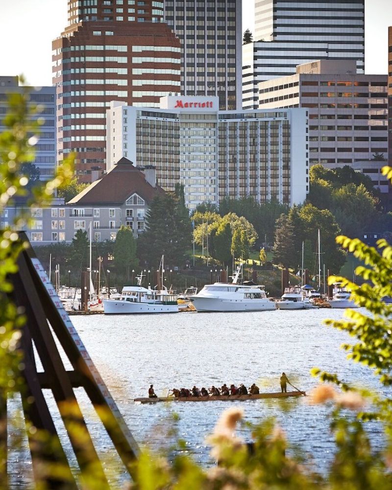 View of the Portland Marriott Downtown Waterfront with rowers paddling in the Willamette in the foreground.