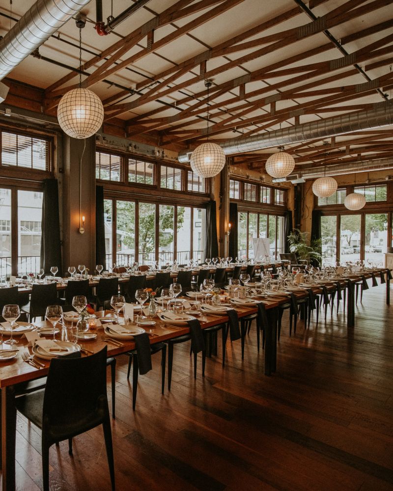 a long table set in a large open dining area with big windows