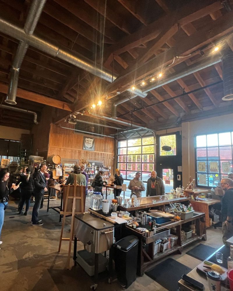 people mingle in a distillery's bottle shop and tasting room