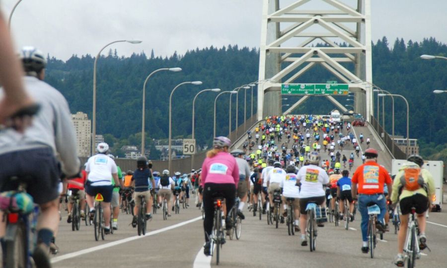 many cyclists crossing a bridge