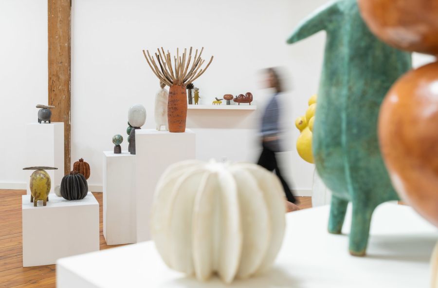 white interior of an art gallery with varied tables holding sculptures
