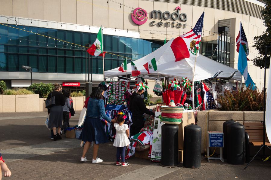 street vendor with Mexican flags sells merchandise outside of an arena venue