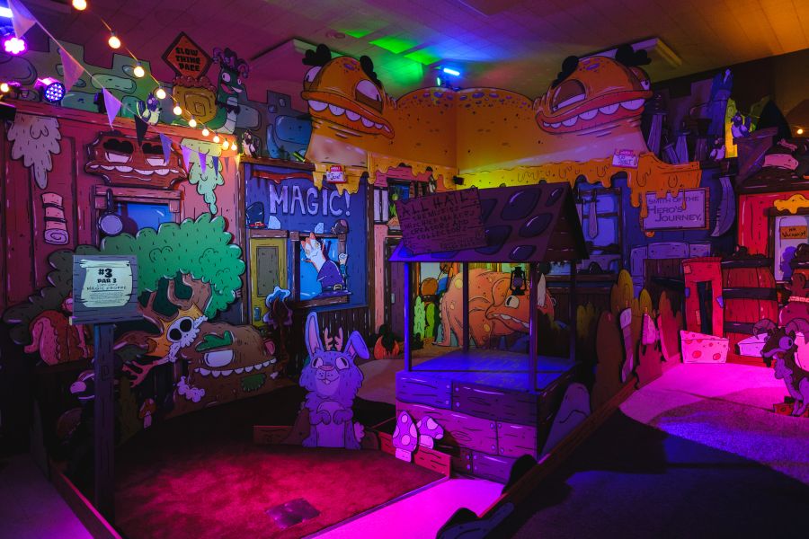 The colorful interior of Wonderwood Springs, a mini golf attraction with cartoon fantasy-themed decorations.