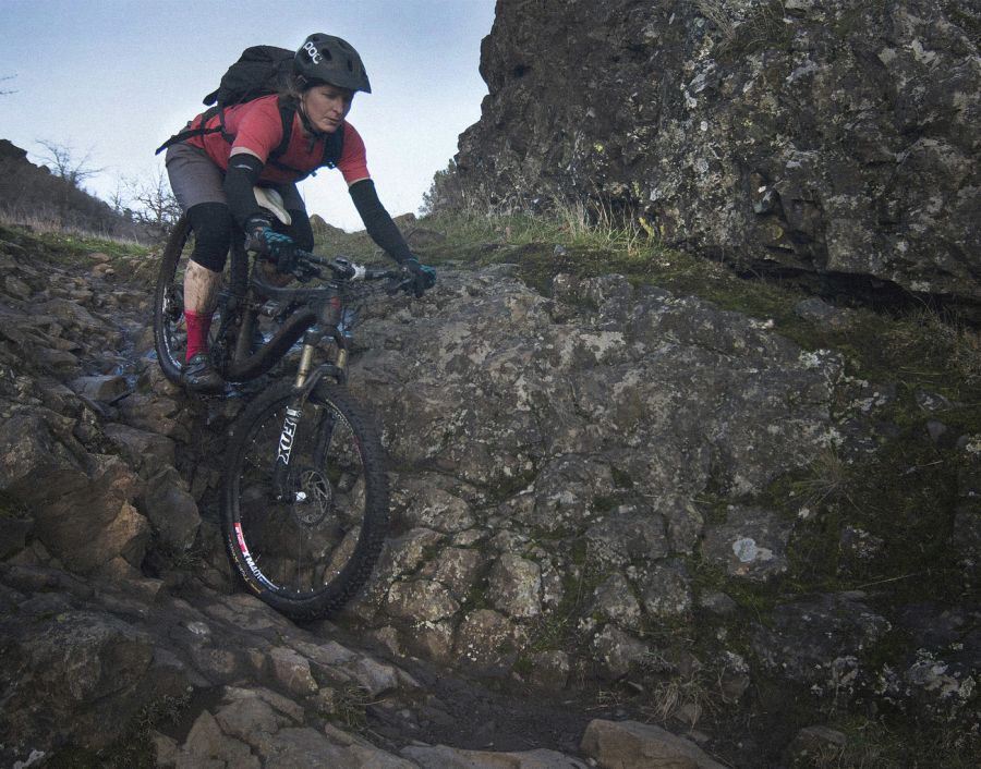 a person mountain biking down steep rocks