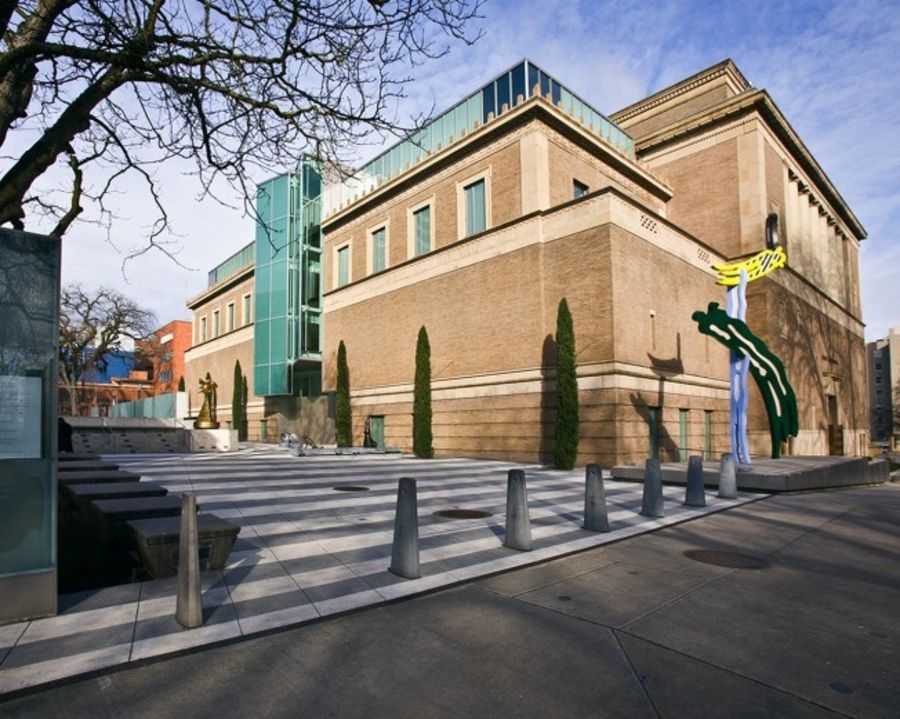 a large brick building, the Portland Art Museum, near a pedestrian crosswalk