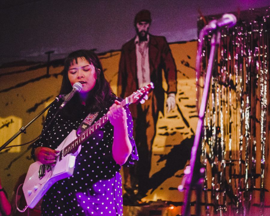 Woman sings with guitar