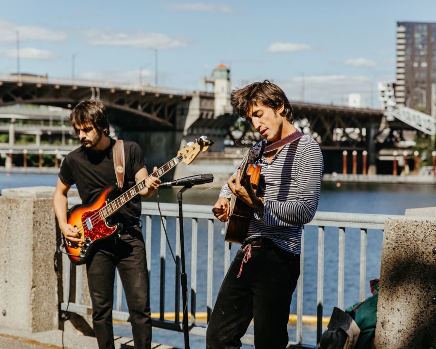 two guitarists busk along the waterfront