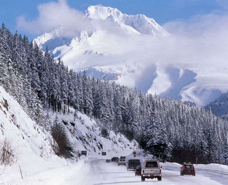 cars driving on snowy highway towards a snow covered Mount Hood