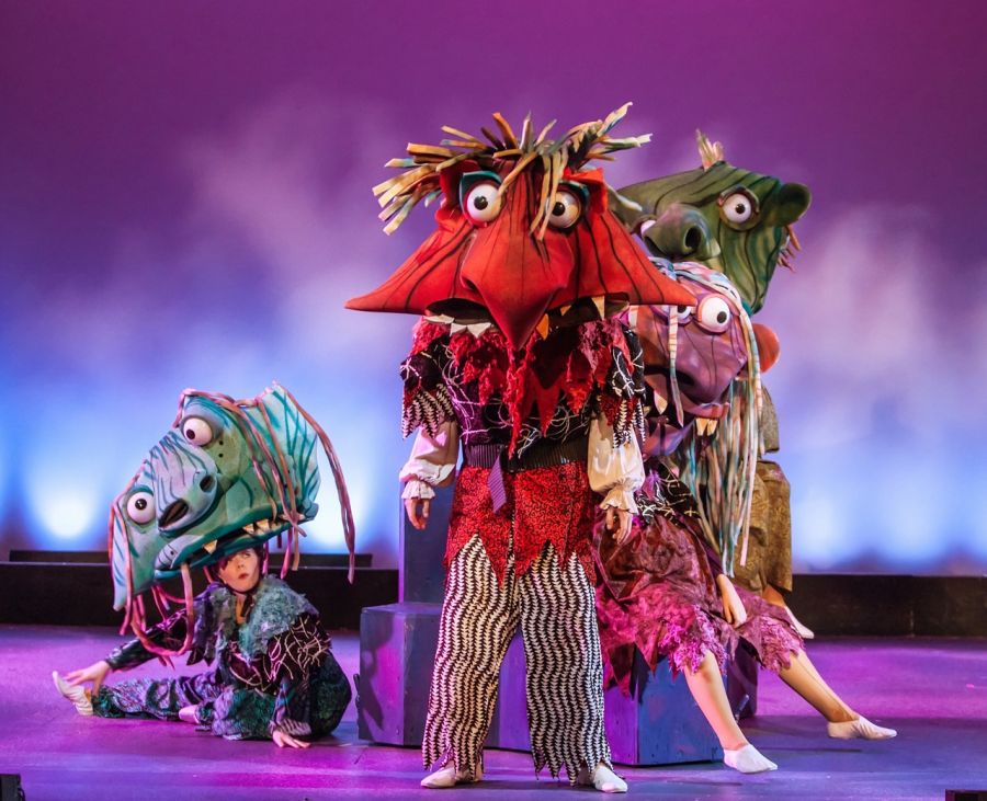 Four large headed scary/funny monsters on stage