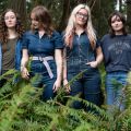 four women standing in a forest