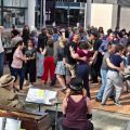 a crowded dance floor filled with couples dancing in front of a band