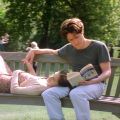 a woman rests her head on a man's lap on a park bench