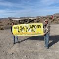 two people hold up a banner that says "nuclear weapons are illegal"