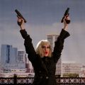 a person holding two hand guns up in front of a city skyline