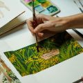 a hand painting an image of vegetation