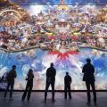 people admiring a large multimedia art work